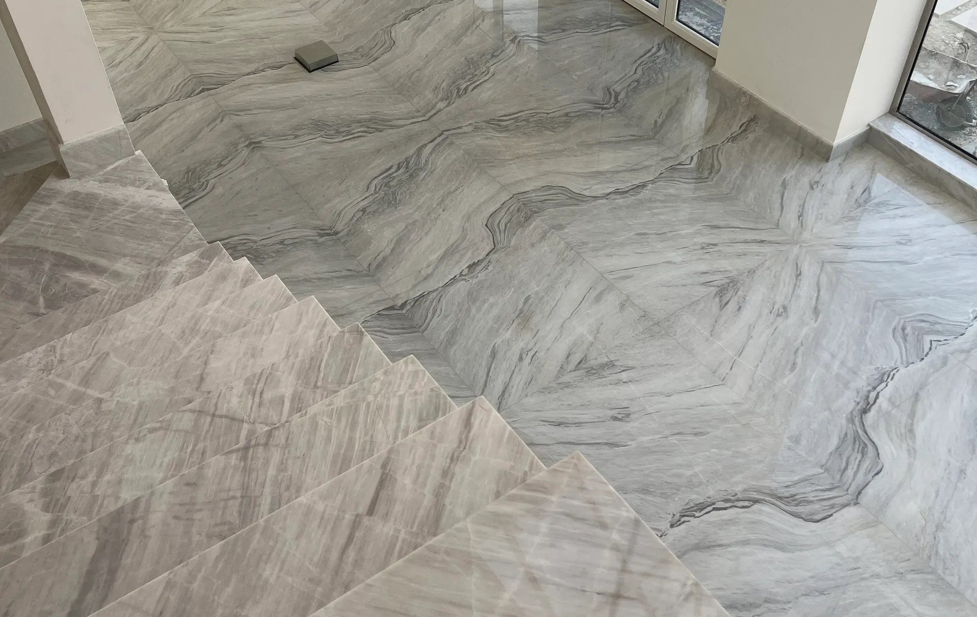 Polished book-matched marble flooring in a finished interior